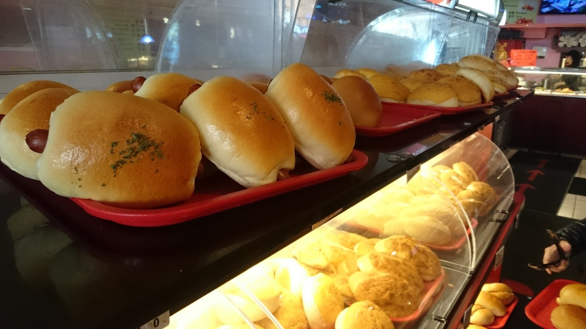 Fresh buns displayed on trays in bakery case