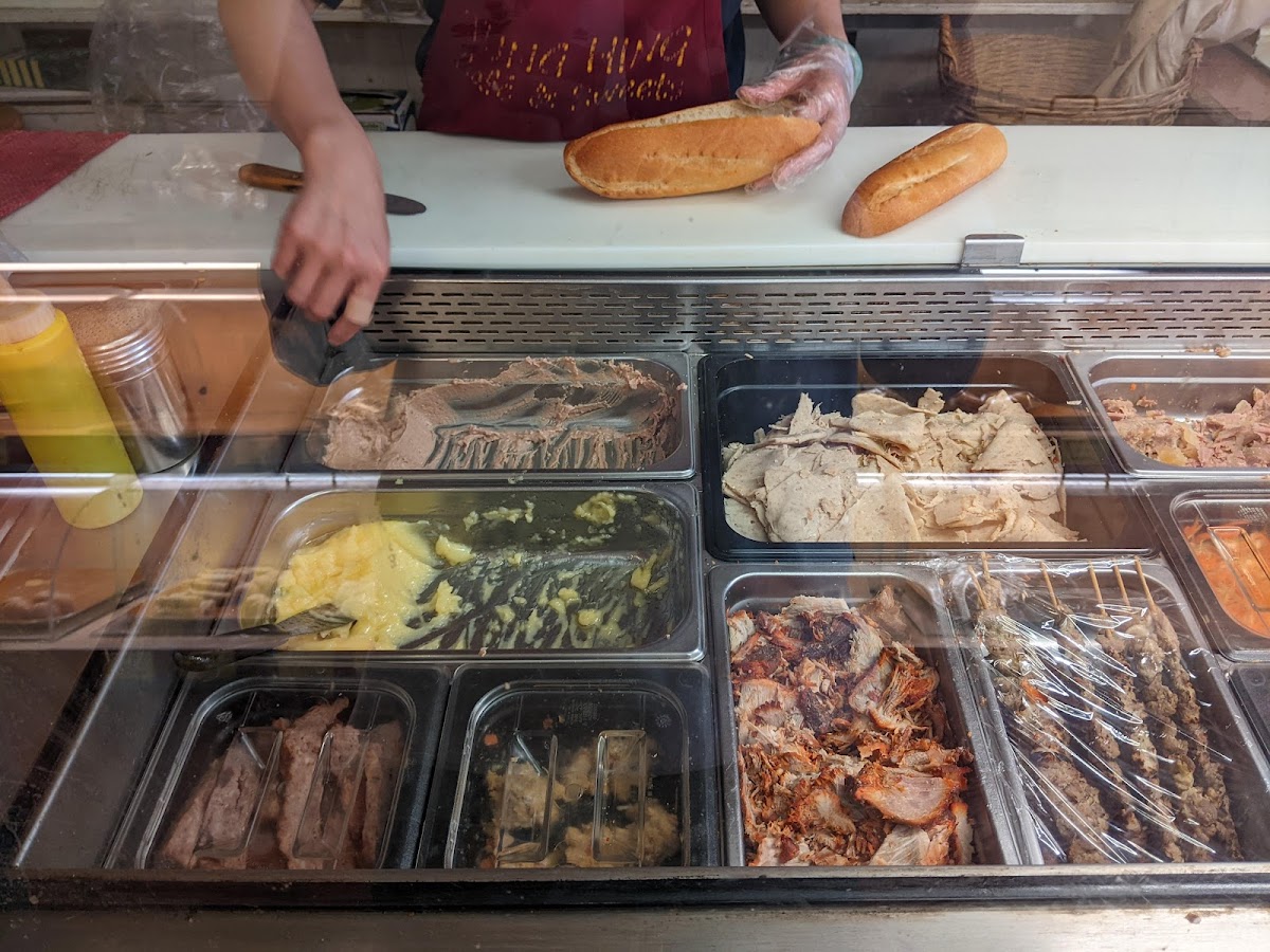 Staff preparing sandwich behind glass counter